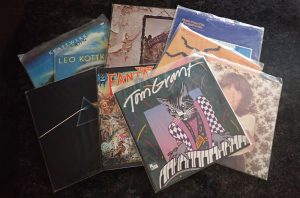 Old vinyl records in their jackets and inside clear protective sleves.